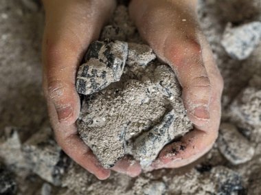 Bir çocuğun elinde yanmış küller. Yaklaş.
