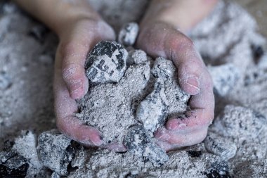 Bir çocuğun elinde yanmış küller. Yaklaş.