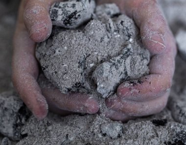 Bir çocuğun elinde yanmış küller. Yaklaş.