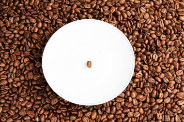 Kahve çekirdeği beyaz bir fincan tabağında.