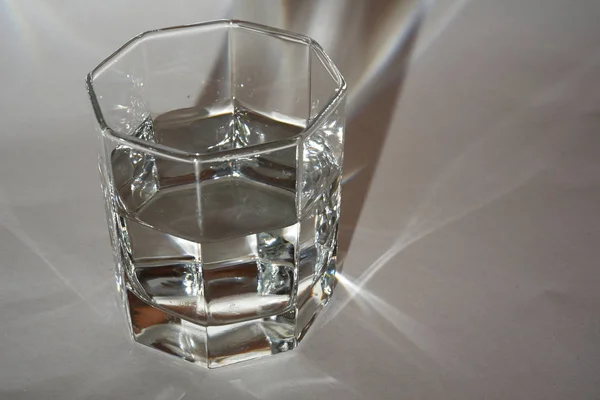 Faceted glass with clear water or liquid — Stock Photo, Image