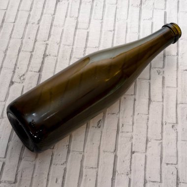 Boş bir şarap şişesi yatay olarak yatıyor.