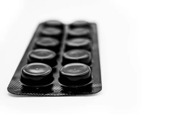 Black blister with pills on a white background — Stok fotoğraf