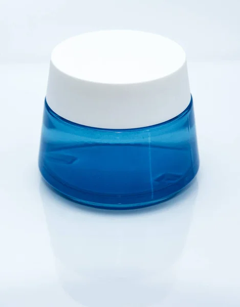 Frasco Azul Con Tapa Con Crema Verticalmente —  Fotos de Stock