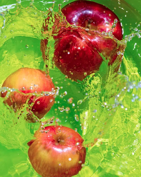 Manzanas Rojas Maduras Agua Con Salpicaduras Fondo Verde Verticalmente — Foto de Stock