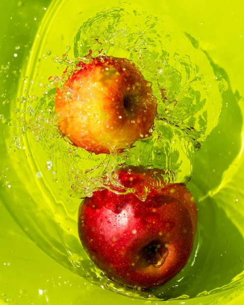 Dos Jugosas Manzanas Maduras Agua Con Salpicaduras Fondo Verde Verticalmente — Foto de Stock