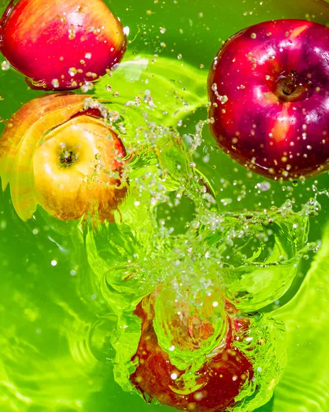 Manzanas Rojas Maduras Agua Con Salpicaduras Fondo Verde Verticalmente — Foto de Stock