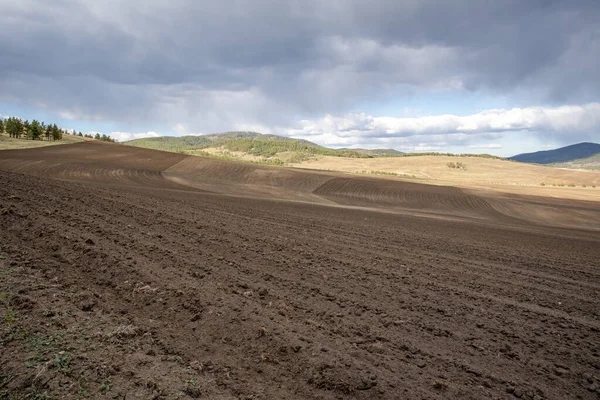 plowed field, arable land, blue sky with clouds, horizontal landscape