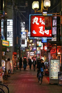 OSAKA, JAPONYA - 22 Kasım 2016: İnsanlar Osaka 'nın Umeda ilçesindeki alışveriş caddesi boyunca bulunan restoranları ziyaret ediyorlar. Osaka, Japonya 'nın ikinci büyük metropol bölgesine aittir (19.3 milyon kişi).).