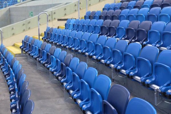 Stadium seats - empty sports venue. Blue plastic chairs.