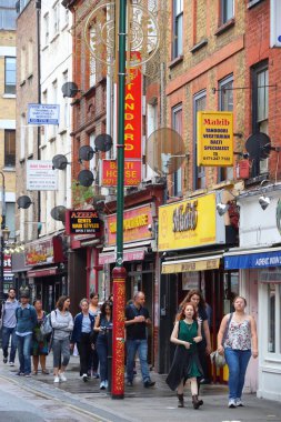 Londra 'nın Shoreditch ilçesinde 13 Temmuz 2019' da insanlar Brick Lane caddesini ziyaret ediyor. Shoreditch çok kültürlü topluluğuyla bilinir..