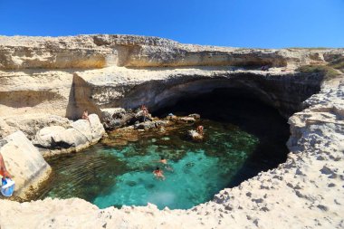 SALENTO, İtalya - 1 Haziran 2017 İnsanlar İtalya 'nın Salento Yarımadası, Roca' daki Grotta Della Poesia yüzme mağarasını ziyaret ediyor. Yıllık 50 milyon ziyaretçiyle İtalya, en çok ziyaret edilen ülkelerden biri oldu..