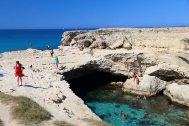 SALENTO, İtalya - 1 Haziran 2017 İnsanlar İtalya 'nın Salento Yarımadası, Roca' daki Grotta Della Poesia yüzme mağarasını ziyaret ediyor. Yıllık 50 milyon ziyaretçiyle İtalya, en çok ziyaret edilen ülkelerden biri oldu..