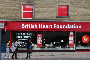 HUDERSFIELD, İngiltere - 10 Temmuz 2016: Insanlar Huddersfield, West Yorkshire, İngiltere 'deki British Heart Foundation yardım dükkanına yürüyorlar. Derneğin İngiltere 'de 700 civarında mağazası vardır..