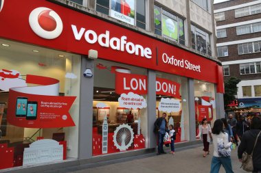 LONDON, İngiltere - 6 Temmuz 2016: Londra 'da insanlar Vodafone cep telefonu dükkanının önünden geçiyor. İngiltere 'de 89.9 milyon cep telefonu abonesi var..