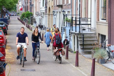 AMSTERDAM, NETHERLANDS - 8 Temmuz 2017: insanlar Amsterdam, Hollanda 'da bisiklet sürerler. Hollanda 'da 13 milyondan fazla bisiklet bulunmaktadır (16.5 milyon nüfusa sahip ülke).).