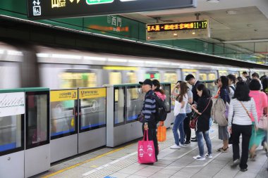 TAIPEI, TAIWAN - 4 Aralık 2018: insanlar Taipei 'de bir metro treni bekliyor. Taipei Mass Rapid Transit (MRT), Taipei Metro olarak markalaştırıldı ve yıllık 746 milyon turla hizmet veriyor..