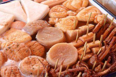 Japanese cuisine - oden food in soy broth. Typical  winter food in Japan with dumplings, tofu and daikon. Tokyo street food. clipart
