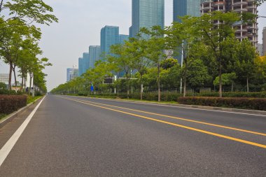 Boş yol yüzeyi ile modern şehir binaları arka plan