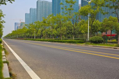 Boş yol yüzeyi ile modern şehir binaları arka plan
