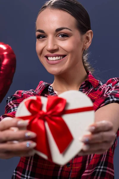 Uśmiecha się kobieta trzymać białe pudełko z czerwony świąteczny — Zdjęcie stockowe