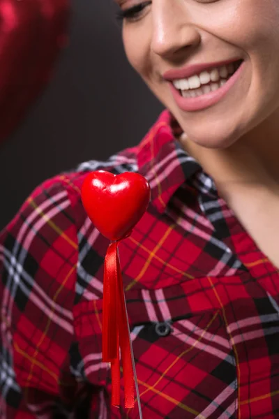 Sexy i uśmiechnięta kobieta trzymając czerwony usłyszeć — Zdjęcie stockowe