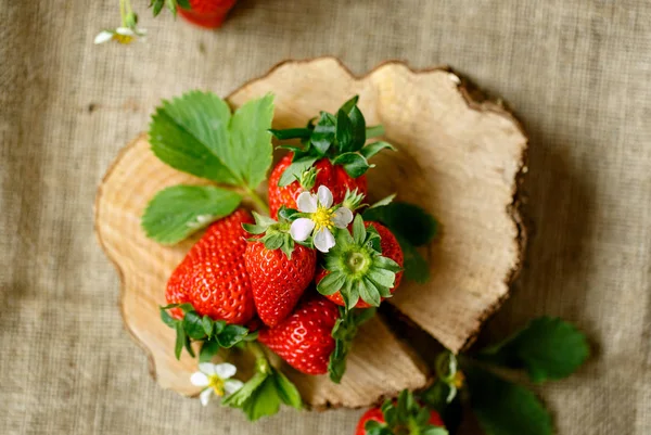 Rote Erdbeeren auf Holz mit Blüten — Stockfoto