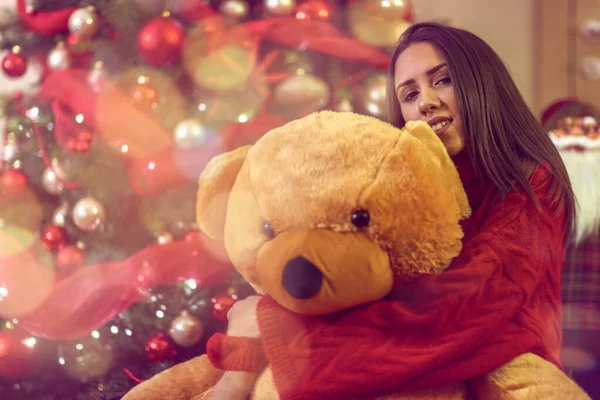 Junge Frau mit Weihnachtsgeschenk. Mädchen umarmt Teddybär Geschenk — Stockfoto