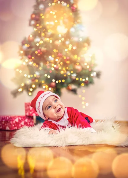 Niedliche Baby-Junge in Weihnachtskostüm und Geschenkbox auf dem Boden zu Hause — Stockfoto