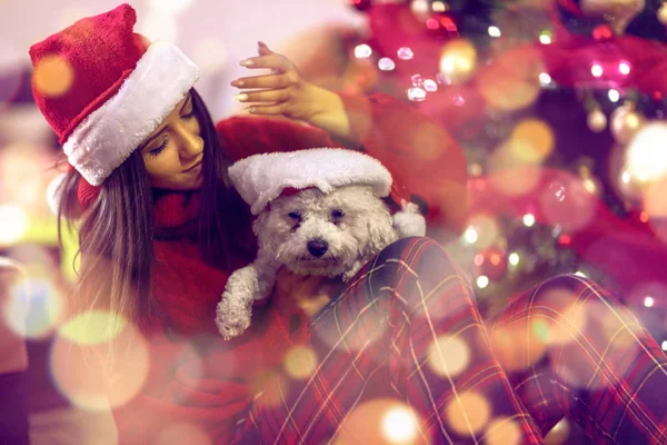 Χαμογελαστή γυναίκα με τα καπέλα santa και το δώρο των Χριστουγέννων. Φωτογραφία Αρχείου