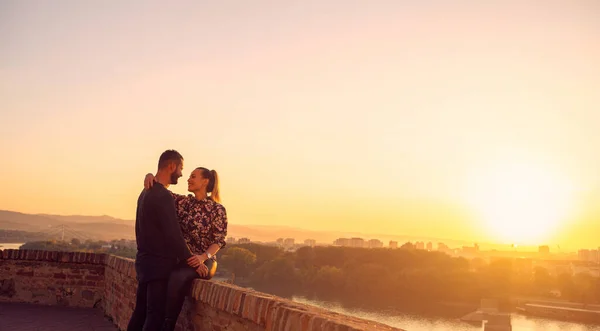 Uśmiechnięta para przytulająca się o zachodzie słońca Obrazek Stockowy