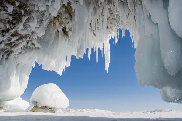 Largos carámbanos azules en la cueva de hielo en acantilados costeros. Fenómenos naturales inusuales del invierno Lago Baikal —  Fotos de Stock