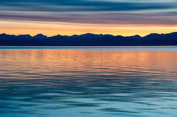 Vacker röd solnedgång över sjön med berg — Stockfoto