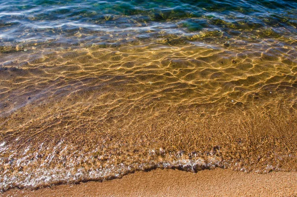 Kumlu sahilde yumuşak bir mavi okyanus dalgası. Arkaplan. — Stok fotoğraf