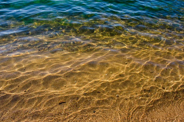 Kumlu sahilde yumuşak bir mavi okyanus dalgası. Arkaplan. — Stok fotoğraf