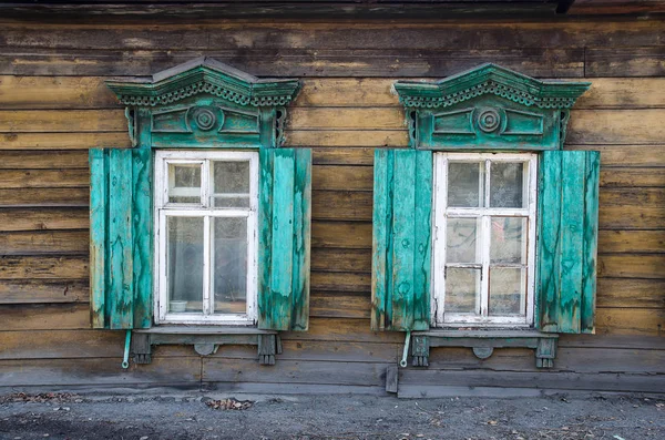 Два окна с резной деревянной архитектурой в старом деревянном доме в старом русском городе . — стоковое фото