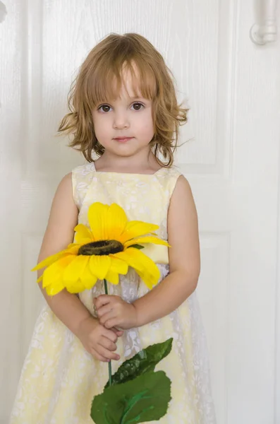 Petite fille mignonne avec un tournesol montres sur la fleur — Photo