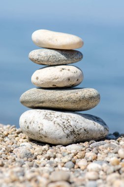 Piramit renkli çakıl. Rock Zen deniz arka planda. Uyum ve denge kavramı.