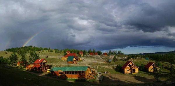 Regenbogen am Himmel unter einem Häuschen auf dem Hügel. — Stockfoto