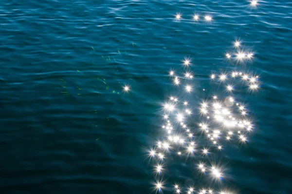 Lumière du soleil scintillant et réfléchissant hors de l'eau du lac. Fond avec effet étoile — Photo