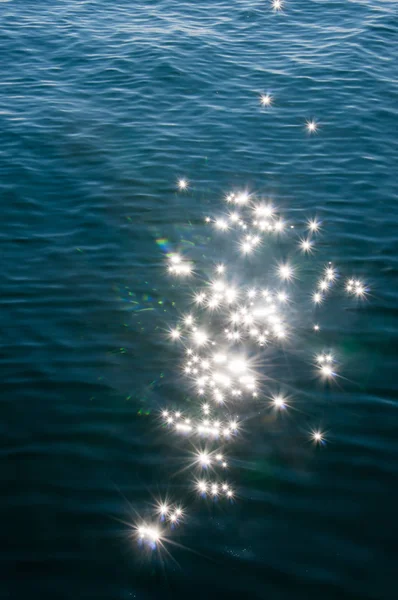 Napfény, szempillantás alatt, és az visszaverődik tó víz. Háttér csillag hatása — Stock Fotó