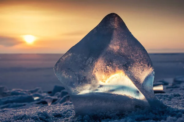 Belo gelo transparente do Lago Baikal contra o céu azul escuro laranja e um sol brilhante — Fotografia de Stock