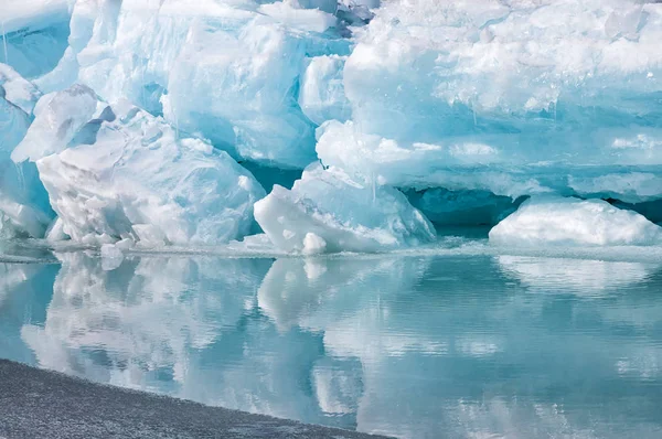 Blue growler piece of iceberg with reflection in calm water. Arctic ocean — Stock Photo, Image