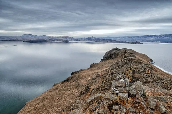 Baikal Lake and Kobilya golova rock in the December cold. Time of freeze-up. Ice floes is swiming on the water — Stock Photo, Image