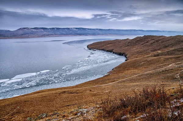 Lago Baikal e roccia nel freddo di dicembre. Tempo di congelamento. I ghiacci nuotano sull'acqua — Foto Stock