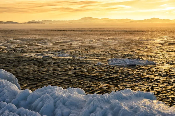 Témpanos de hielo flotando en el agua de niebla en el lago Baikal. Puesta de sol — Foto de Stock