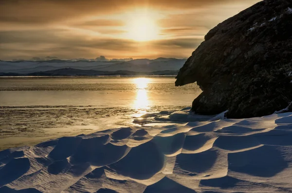 Tramonto invernale vicino alle rocce con neve il lago ghiacciato di Baikal — Foto Stock