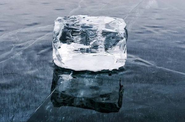 Cubo de gelo único com reflexão sobre a superfície do lago — Fotografia de Stock