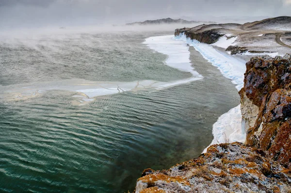 Lago Baikal y roca en el frío de diciembre. Tiempo de congelación. Los témpanos de hielo nadan en el agua —  Fotos de Stock