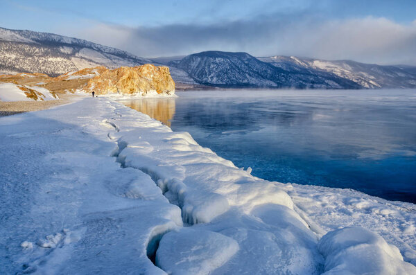 Field of ice hummocks and rock on the frozen Lake Baikal. Sunrise